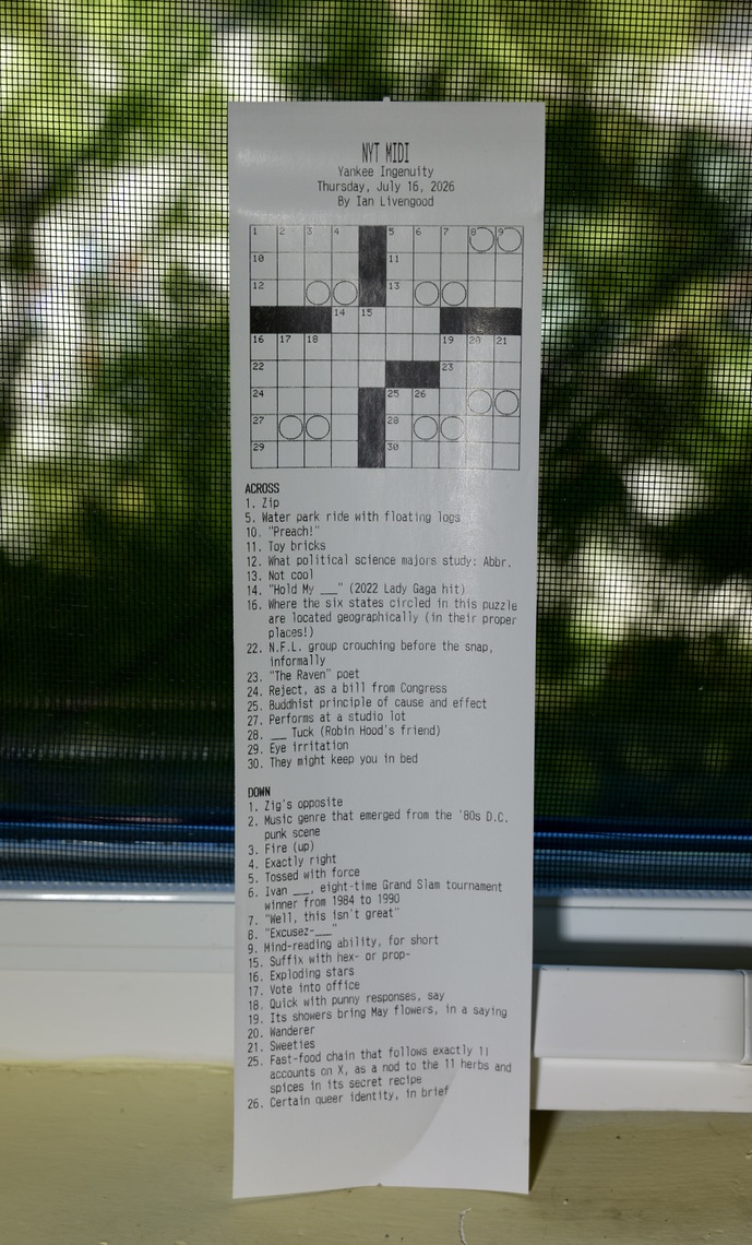 A crossword grid and clues printed on a long thermal receipt